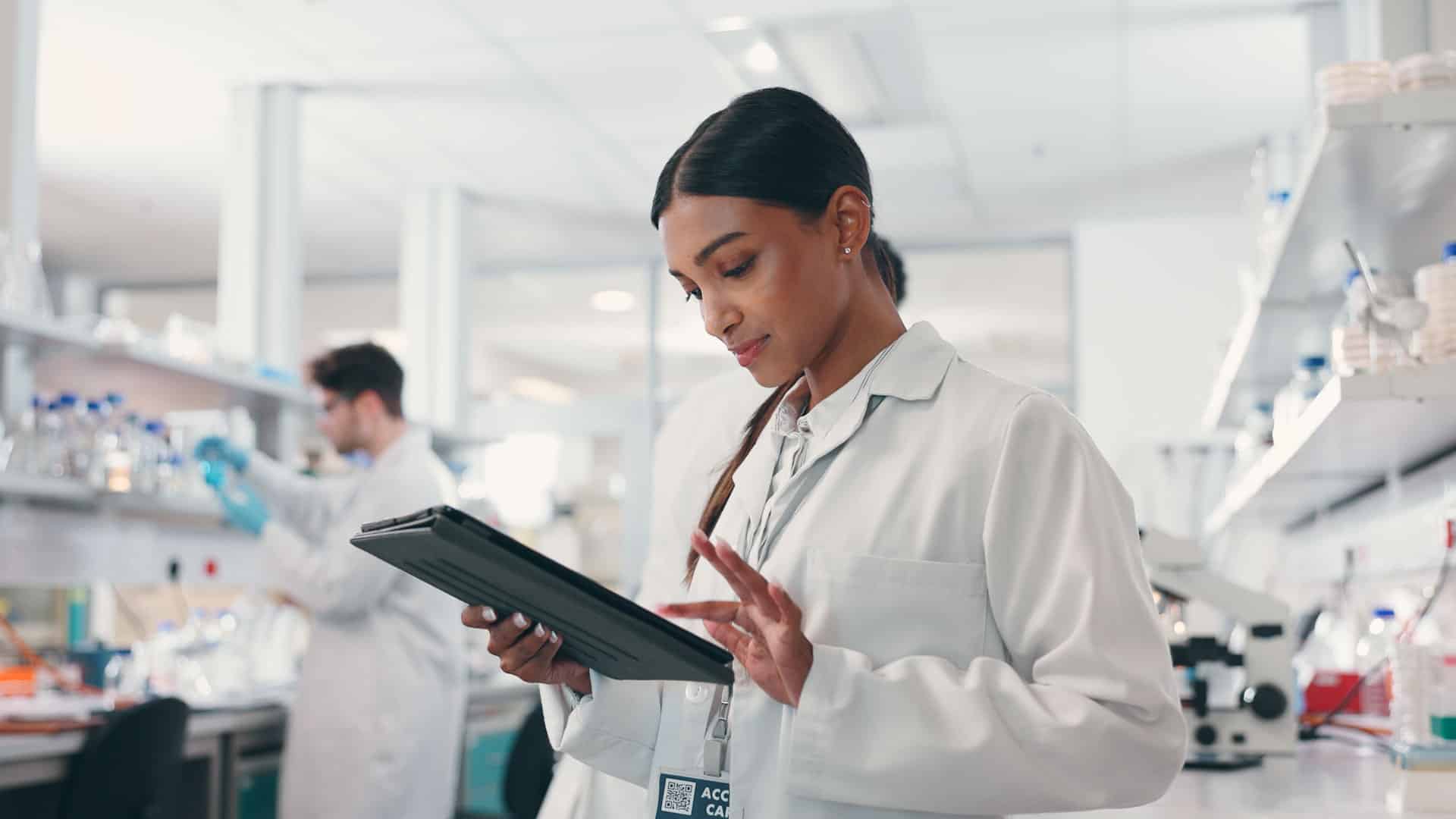 Worker using a tablet in a lab at a pharmaceutical company